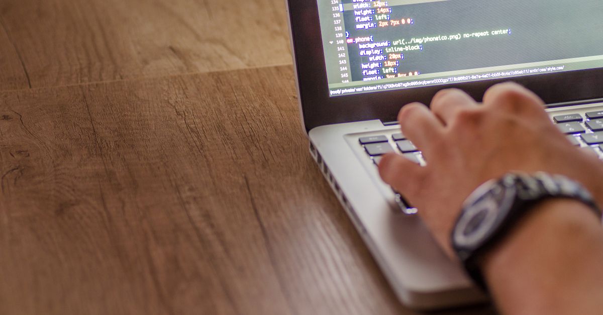 criação de site em Pederneiras — Close-up de uma pessoa codificando em um laptop, destacando conceitos de desenvolvimento web e programação.