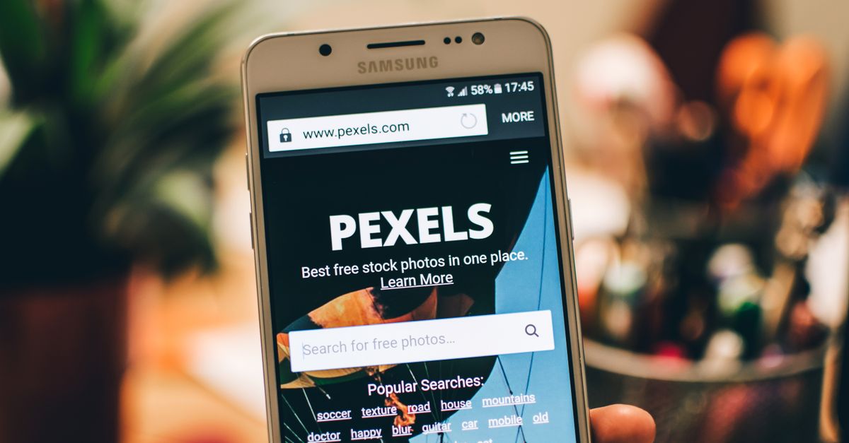 criação de site em Pederneiras — Uma vista aproximada de um smartphone exibindo a tela do site Pexels para buscas de fotos de estoque.